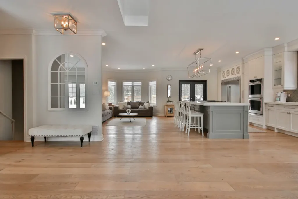 Open-concept kitchen and living room with a large island and light wood flooring